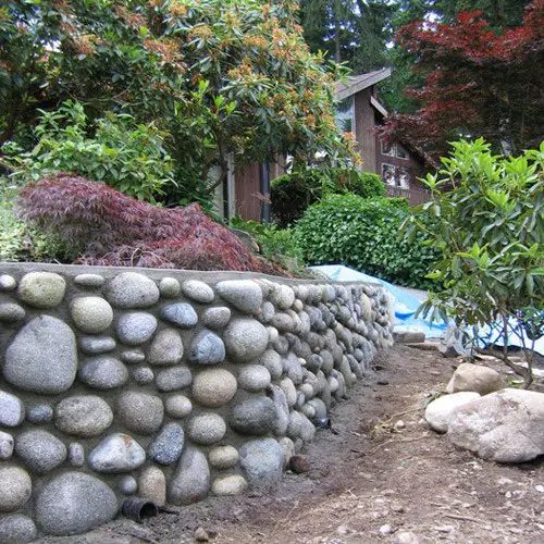 Building river stone walls with mortar in the garden